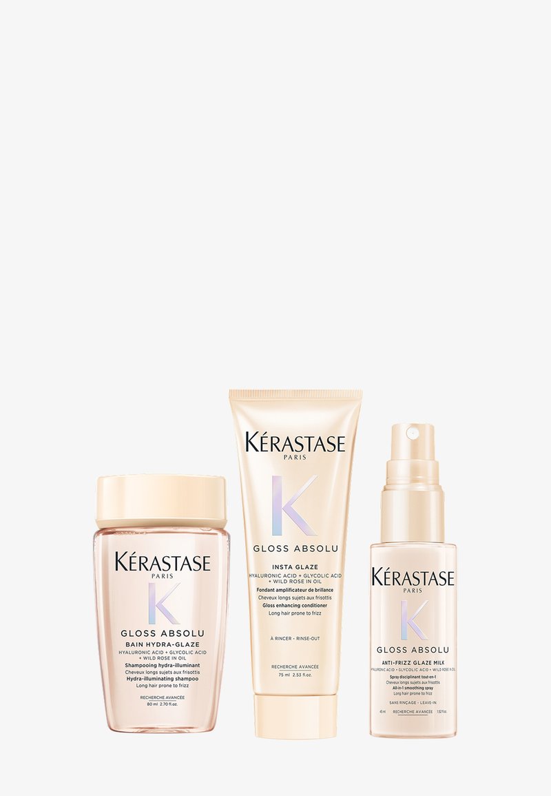 Juego de cuidado capilar Kérastase Gloss Absolu que incluye un tarro transparente, un tubo de crema y una botella pulverizadora en un suave packaging rosa y dorado.