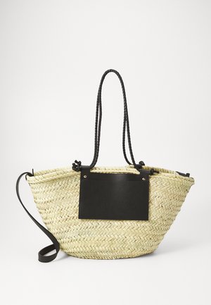Tkanasta torba od slame u svijetlopjeloj boji, s crnim kožnim detaljem s urezanim tekstom, dvostrukim pletenim ručkama i širokim, otvorenim oblikom.