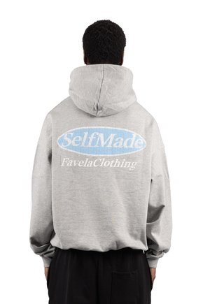 Personne de dos, portant un sweat à capuche gris avec "SelfMade" et "FavelaClothing" imprimés en blanc et bleu au dos.