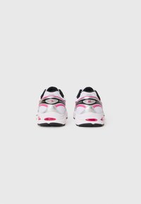 Scarpe sportive bianche con accenti neri, dettagli argentati e evidenziazioni rosa. Presentano una parte superiore in rete testurizzata e un colletto imbottito per il comfort.