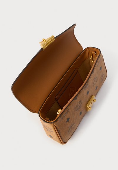 Καφέ δερμάτινη τσάντα σχεδιαστή με χρυσό κούμπωμα, ανοιχτό καπάκι, φερμουάρ σε θήκη και ανάγλυφο σχέδιο λογότυπου στην εξωτερική επιφάνεια και στις εσωτερικές θήκες καρτών.