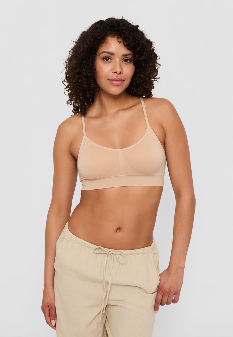 Beige, sömlös bralette med tunna axelband och rundad halsringning. Mjuk, elastisk tyg som är utformat för att ge lätt stöd och komfort.