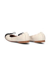 Ballet flats in crèmekleurig leer met een zwarte neus, voorzien van een klein strikje en een flexibele, licht afgeronde zool.