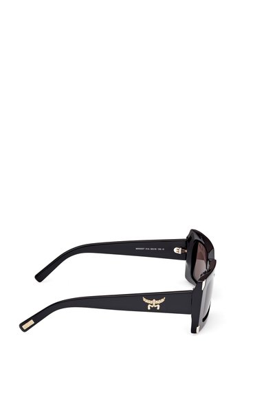 Ochelari de soare negri cu rame groase și unghiulare. Lentile întunecate și un accent cu logo auriu pe bradă. Finisaj din plastic neted, design modern.