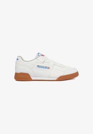 Zapatilla blanca Reebok de corte bajo con suela de goma, logotipo azul de Reebok en el lateral, la lengüeta y el talón, y cierre de cordones.