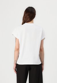 White, short-sleeve cotton T-shirt with a round neckline and slightly dropped shoulders; fabric appears smooth and soft; no visible patterns.