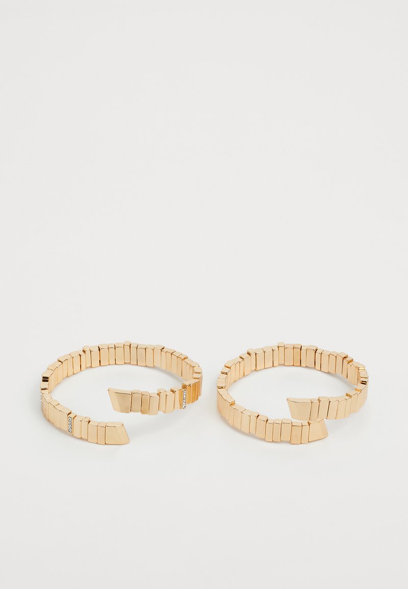 Aukso tono apyrankės su segmentuotais metaliniais grandinėlėmis, kiekviena su geometriška forma ir viena papuošta mažomis kalnų kristalais.