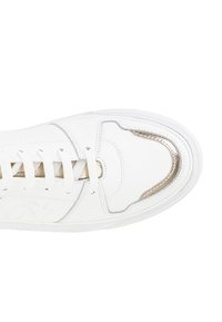 Sneaker bianco in pelle con texture liscia, dettagli dorati attorno ai lacci e punta arrotondata. Caratterizzato da lacci rotondi e un dettaglio laterale con il marchio.