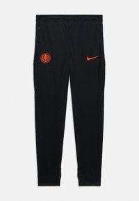 Melnas sporta bikses, kas izgatavotas no viegla auduma, ar oranžiem Nike logotipu un oranžiem apļveida simboliem. Iekļautas ir kabatas ar rāvējslēdzējiem un elastīgas aproces.
