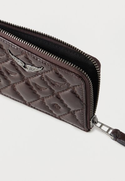 Καφέ δερμάτινο πορτοφόλι με ραμμένη επένδυση και ασημένιο φερμουάρ, με διακοσμητικό έμβλημα φτερού και υφασμένη επιφάνεια για καλύτερη λαβή.