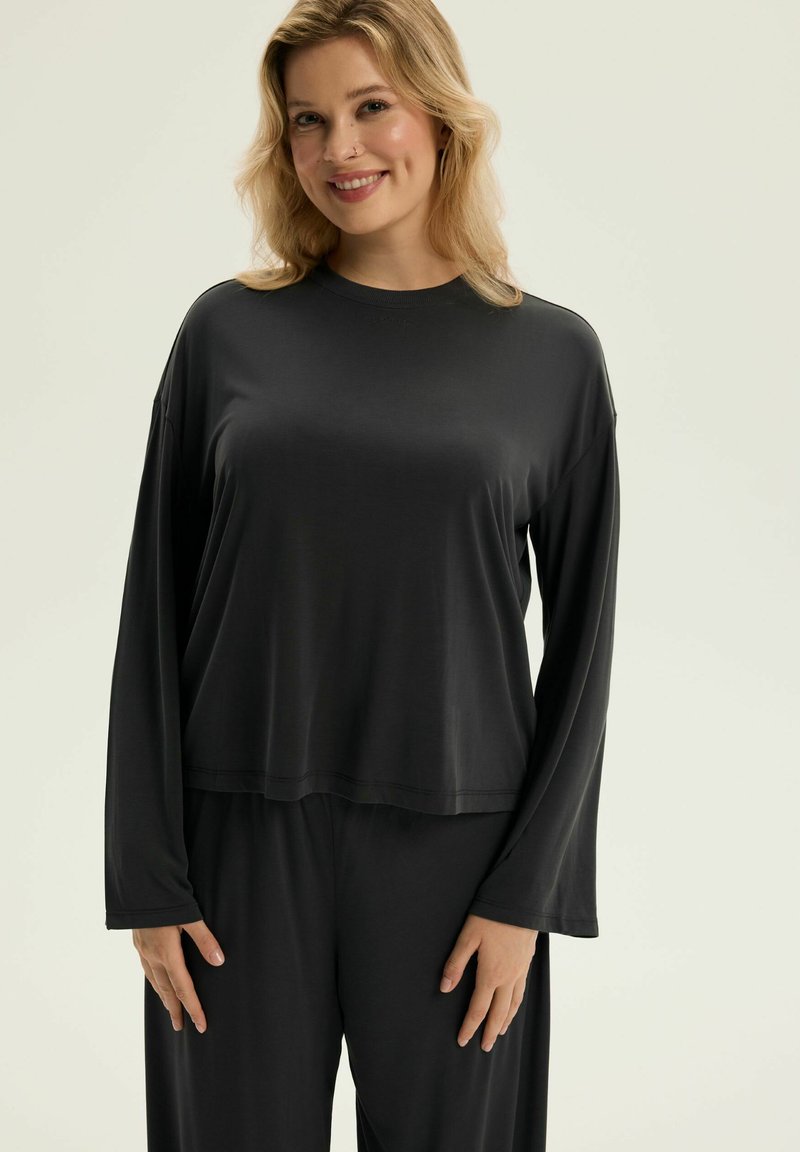 Czarny, długi rękaw top z luźnym krojem i okrągłym dekoltem, w komplecie z pasującymi szerokimi spodniami; wykonany z gładkiego, lekkiego materiału.