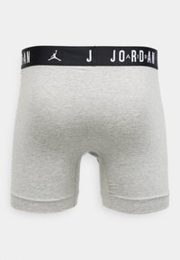 Grijze katoenen boxershorts met een zwarte elastische tailleband met witte "JORDAN"-branding en een Jumpman-logo. Glad oppervlak en een nauwsluitend ontwerp.