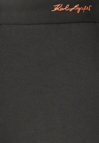 Svarta leggings gjorda av en slät bomullsblandning. Har en broderad orange logotyp på midjebandet. Tight passform.