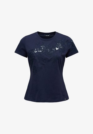 T-shirt bleu marine à manches courtes avec un col rond et une superposition de dentelle florale foncée sur la poitrine et l'épaule droite.
