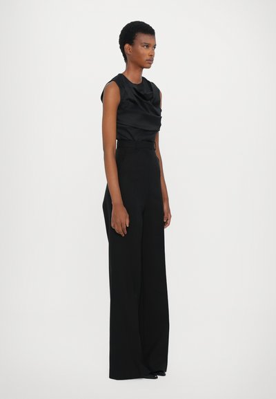 Black sleeveless top with a draped neckline paired with high-waisted, wide-leg black trousers. Both made from smooth fabric.