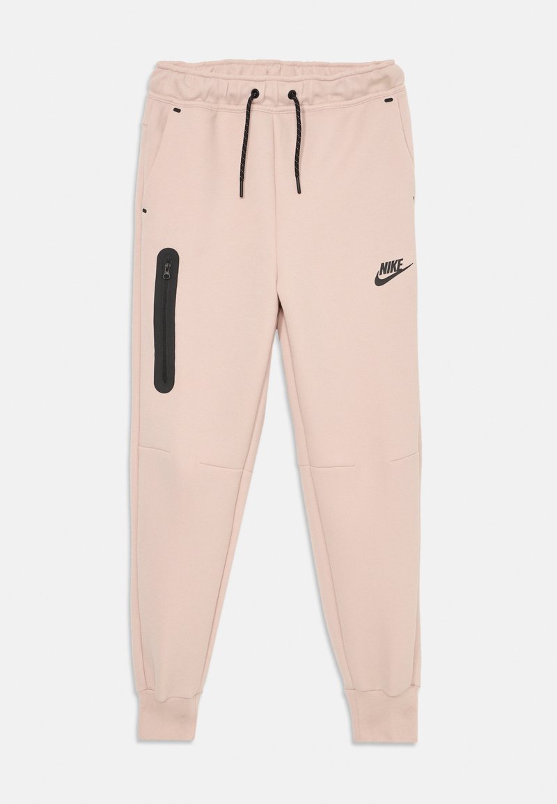 Ljust rosa Nike sweatpants med svarta dragsnoddar, en ficka med dragkedja på vänster lår, och elastiska muddar vid anklarna.