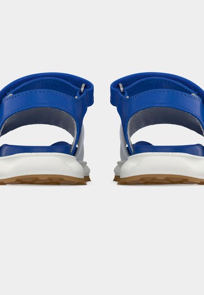 Μπλε αθλητικά σανδάλια με ρυθμιζόμενους ιμάντες και άσπρες μαλακές σόλες, σε θέαση από πίσω σε λευκό φόντο.