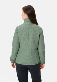 Gewatteerde, lichtgewicht jas in gedempt groen, met een hoge kraag, een gecapitonneerd patroon en elastische manchetten, ontworpen voor comfort en warmte.