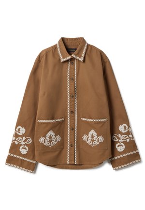 Camisa marrón de manga larga con botones, detalles bordados blancos de flores en los puños y los bolsillos, y ribete blanco a lo largo del cuello y la tapeta de botones.