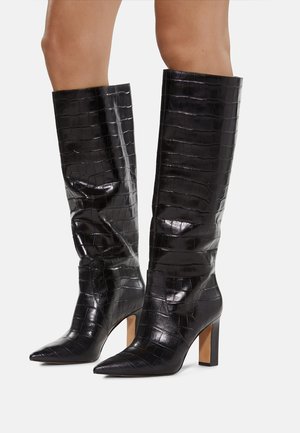 Zwarte kniehoge laarzen met een glanzende krokodillentextuur, spitse neuzen en stevige hakken. Het ontwerp heeft een getailleerde silhoutte en strakke lijnen.