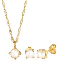 Set di gioielli in tono oro, composto da una collana con catena intrecciata e un pendente rotondo in pietra bianca, accompagnato da orecchini a perno con gemma rotonda coordinata.