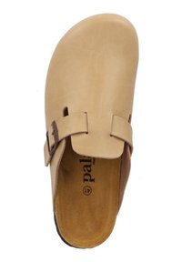 Beige läderträsko med en bred rem och två metalldetaljer, med en mjuk mockainläggssula och en mörk gummisula.