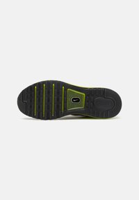 Semelle de chaussure Nike noire et verte avec un motif à carreaux en relief, logo Nike Swoosh visible, et "AIR" embossé sur le talon.