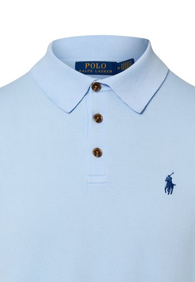 Polo bleu clair avec trois boutons marron, un col replié et un petit logo brodé d'un joueur de polo bleu marine sur la poitrine.