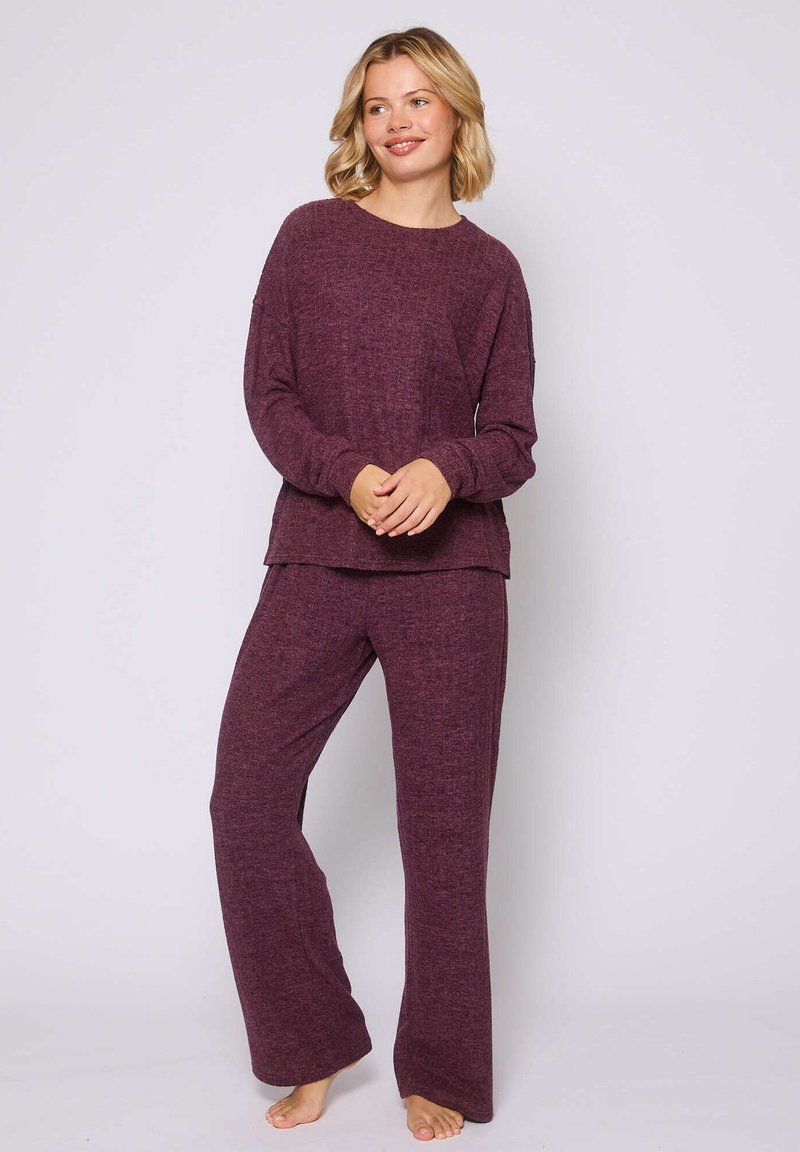 Conjunto de pijama de dos piezas en un profundo color burdeos. La parte superior tiene un corte relajado con mangas largas, y los pantalones son holgados con piernas rectas.