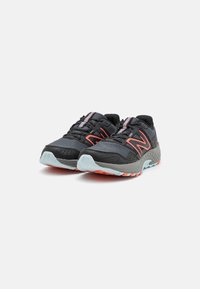 Zapatillas negras para correr con parte superior de malla, acentuadas por detalles en rosa neón, que cuentan con una suela gris acolchada y un patrón de suela exterior en contraste.