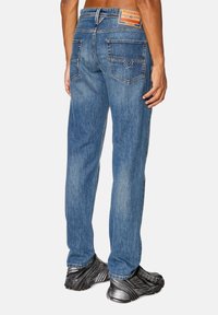 Blå denimjeans med rak passform, med en läderlogo på baksidan, två bakfickor och en lätt urtvättad textur.