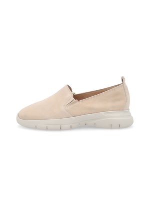 Zapato casual beige tipo slip-on con parte superior suave, tacón bajo, paneles laterales elásticos y suela gruesa de goma blanca para comodidad y fácil uso.