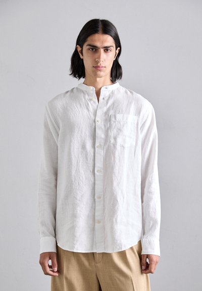 Chemise blanche en lin à manches longues avec col mandarin, texture subtile et poche poitrine. Équipée d'une fermeture à boutons et d'une coupe décontractée.