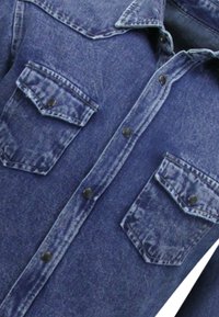Blauwe denim overhemd met knoopsluiting aan de voorkant, twee borstzakken met flappen en een gespreide kraag. Gelaagd stof met vervaagde details.