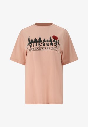 Lyserød T-shirt med korte ærmer med sort skovsilhuet, rød sol og teksten "Whistler Exploring the Will Is Where the Adventure Begins" foran.