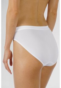 Slip alto bianco realizzato in tessuto morbido e elasticizzato, con una cintura morbida e bordi senza cuciture per comfort e flessibilità.