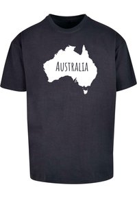 Zwarte katoenen T-shirt met een witte omtrek van Australië en het woord "AUSTRALIË" gecentreerd in de kaart. Korte mouwen, relaxte pasvorm.