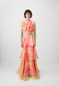 Halterkleid mit einem gestuften, fließenden Rock. Aus durchscheinendem Stoff in rosa- und gelbtönen mit einem wellenförmigen Muster gefertigt. Elastischer Taillenbund.