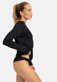 Black long-sleeve top made from smooth fabric, featuring a fitted design and rounded neckline. Paired with dark ribbed bikini bottoms.