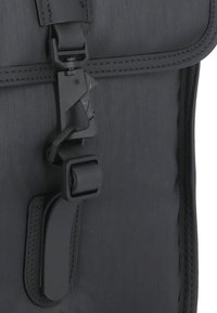Borsa in tessuto nero con una fibbia e una tracolla distintive. Presenta linee eleganti e cuciture, progettata per funzionalità e durata.
