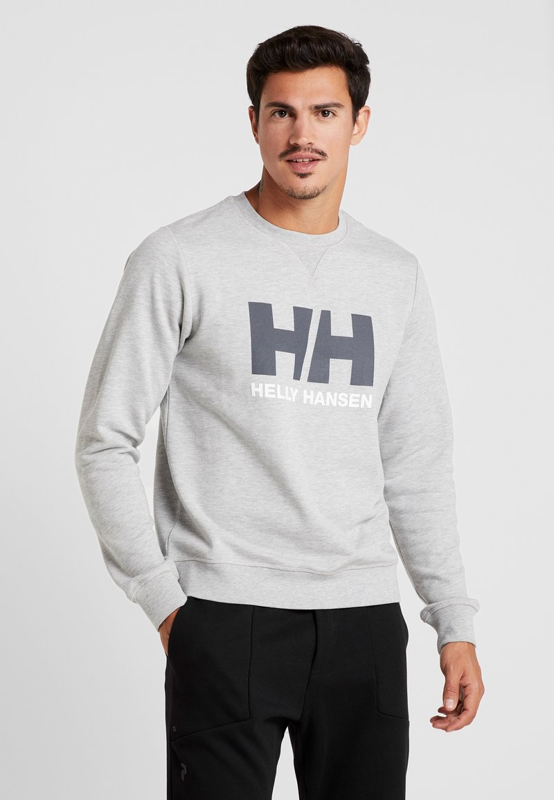 Sudadera gris hecha de una tela suave, con un gran logo en azul oscuro "HH" y texto blanco que dice "HELLY HANSEN" en la parte frontal.