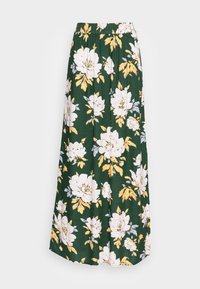 Jupe maxi florale en tissu vert avec des motifs de fleurs blanches et jaunes, une taille élastique et une silhouette fluide et ample.