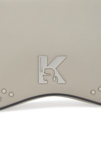 Portafoglio grigio in ecopelle con logo metallico argento e dettagli accentuati lungo il bordo inferiore con perforazioni circolari.