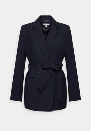 Mørkeblå blazer med en tætsiddende design, dobbeltknaplukning, sidelommer og en bundet taljerem. Glat stoftekstur.