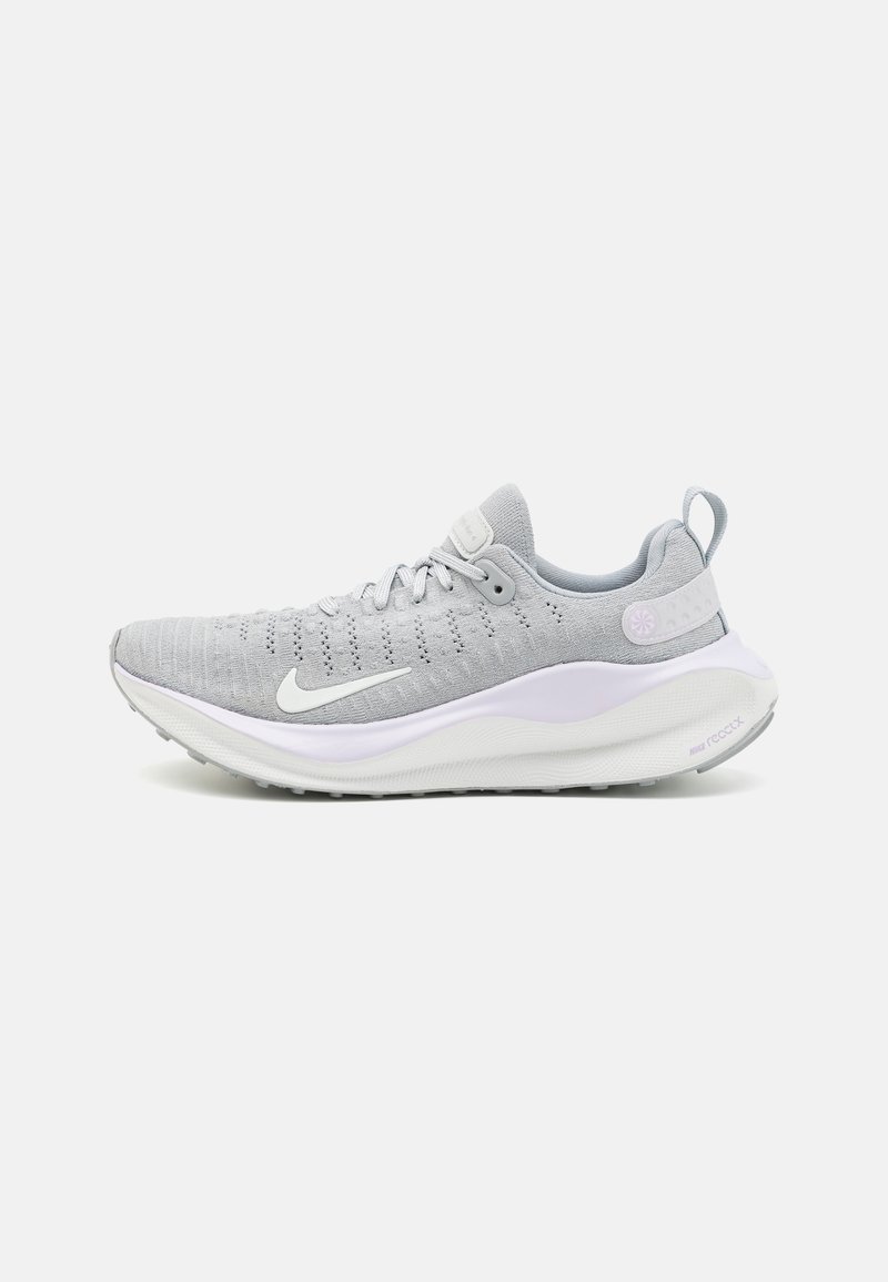 Chaussure de course Nike gris clair avec swoosh blanc, tige tricotée, semelle amortie et languette au talon, vue de côté extérieur sur fond blanc.