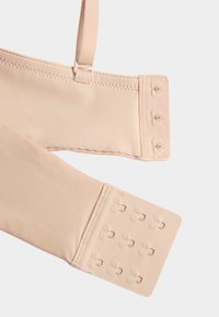 Beige bra strap with adjustable slider and two hook-and-eye closures, one with three hooks and the other with twelve hooks.