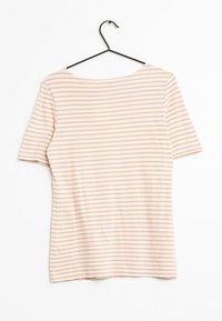 Koszulka w paski z różowymi i białymi poziomymi paskami, krótkimi rękawami i szerokim dekoltem. Miękka tkanina o gładkiej fakturze. Wisi na czarnym wieszaku.