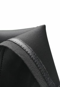 Borsa con zip in tessuto nero con finitura testurizzata e dettagli in pelle liscia. Caratterizzata da un angolo ripiegato e da una robusta cucitura decorativa.