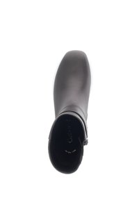 Schwarze Knöchelstiefel mit einer glatten, matten Oberfläche. Quadratzehe, seitlicher Reißverschluss und dezente Markenkennzeichnung im Inneren sichtbar. Flache Sohle und schlankes Design.
