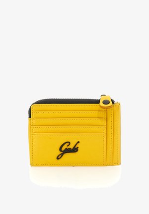 Portacarte in pelle gialla con quattro slot per carte, una tasca con cerniera nera e un logo nero "Gabs" sulla parte anteriore.